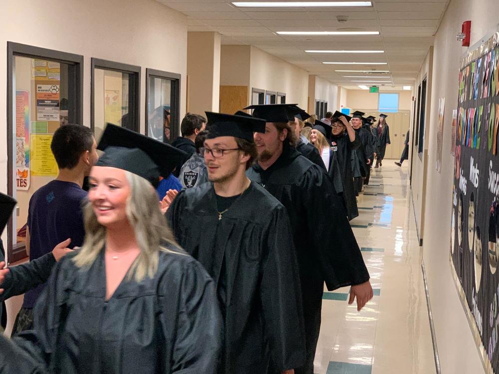 A picture of seniors walking through an elementary school hallway. 