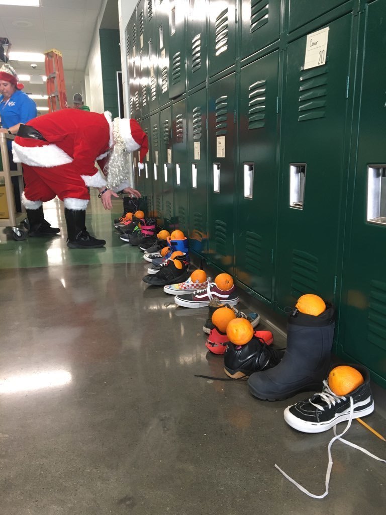 St. Nicholas putting oranges into student's shoes