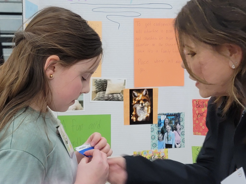 Mrs. Olson giving a student a ribbon