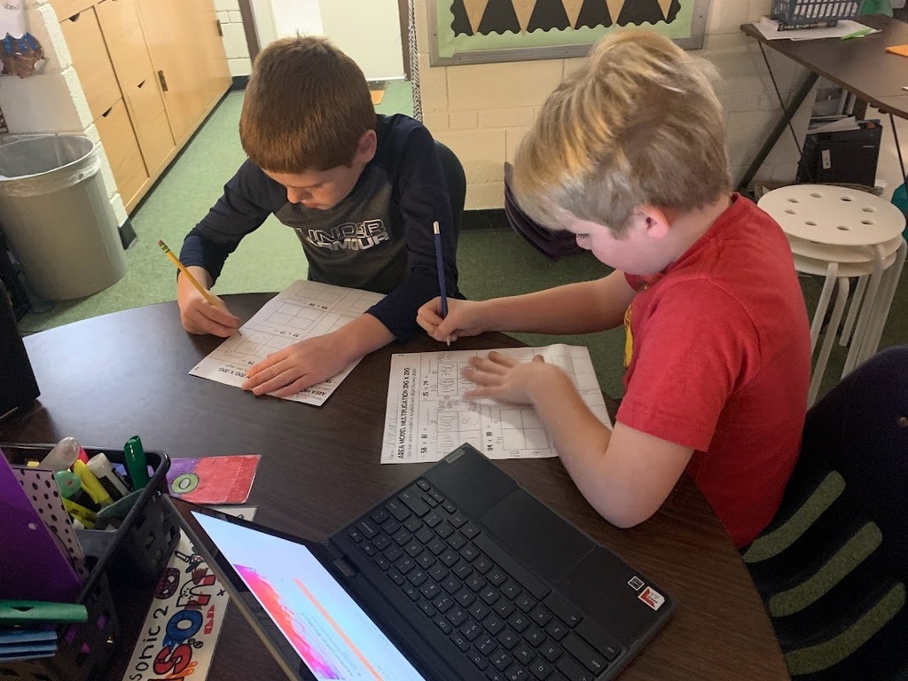  Two students at table filling out worksheet